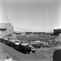 Lastebiler i kø for å losse jernbanevogner på Ila pir