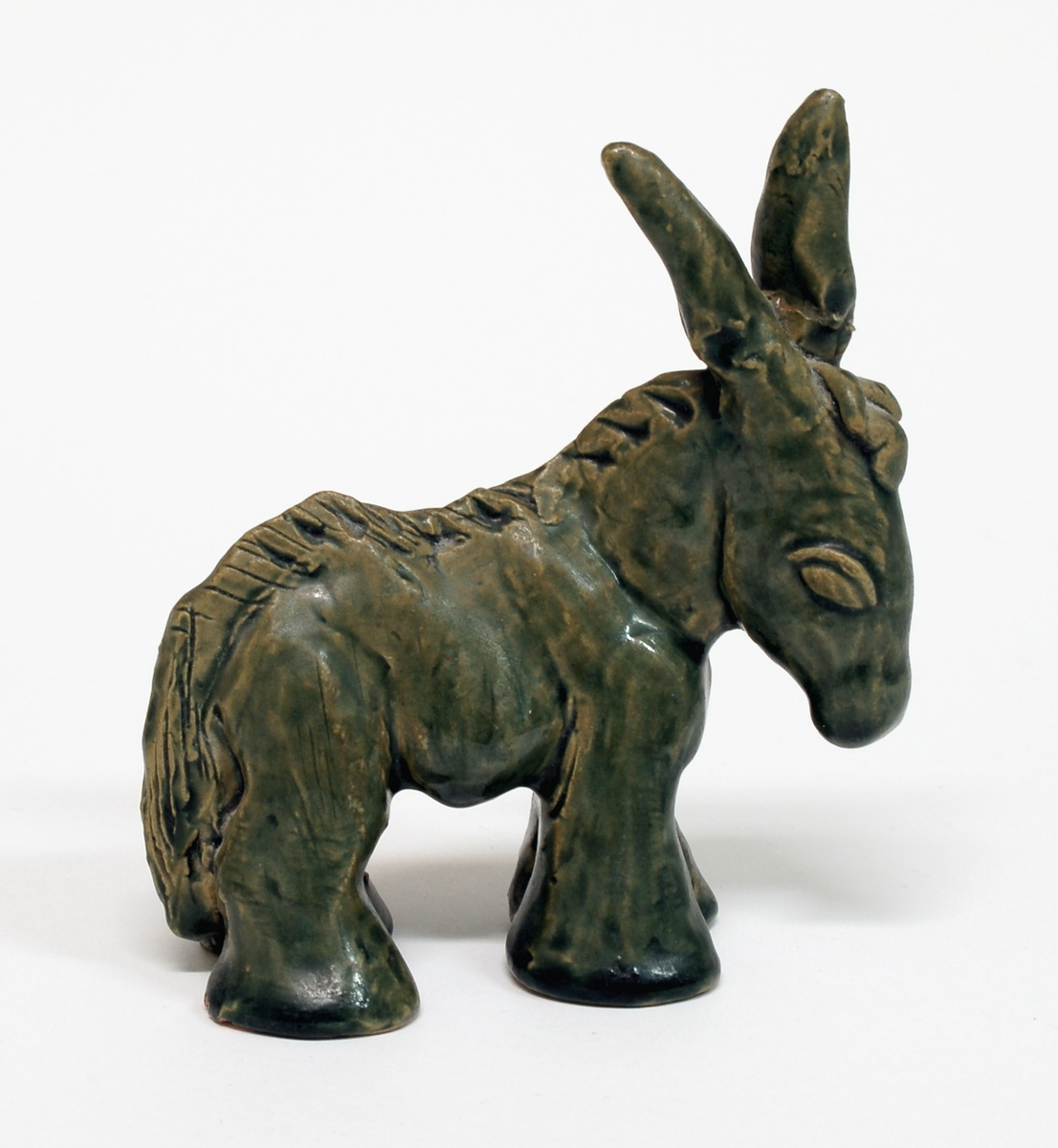 Figurin, åsna, keramik, grön glasyr, formgiven av Märta Willborg, 1930-talet.