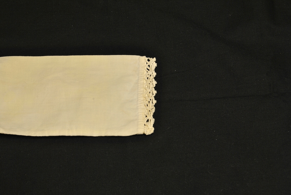 Barnetrøye med blondekrage og nuppereller på ermene. Noe gulnet og flekkete.