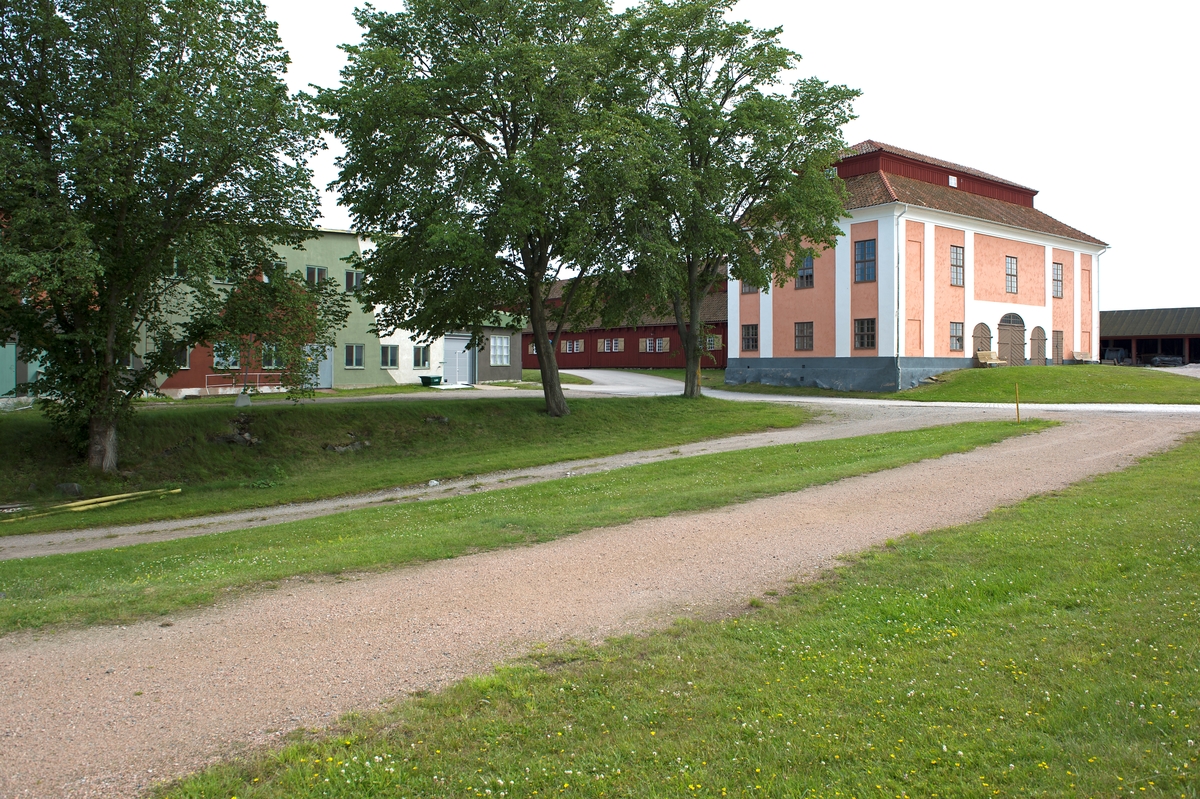 Fotodokumentation av byggnader på Lindholmen i Karlskrona. Till vänster MTB-hallen. Till höger Reslagarbanans västra banhuvud. Repslagarbanan är en av Karlskronas äldsta bevarade byggnader. Träbyggnaden är över 300 meter lång (1000 fot). Byggnaden tillkom på 1690-talet. Här tillverkades fram till år 1960 alla typer av tågvirke för seglande örlogsfartyg. I banhuvudena förbereddes hampan, råvaran till repen. När repslagarna slog repen gick de omväxlande framlänges och baklänges genom banan. År 1969 blev Repslagarbanan byggnadsminnesmärkt.