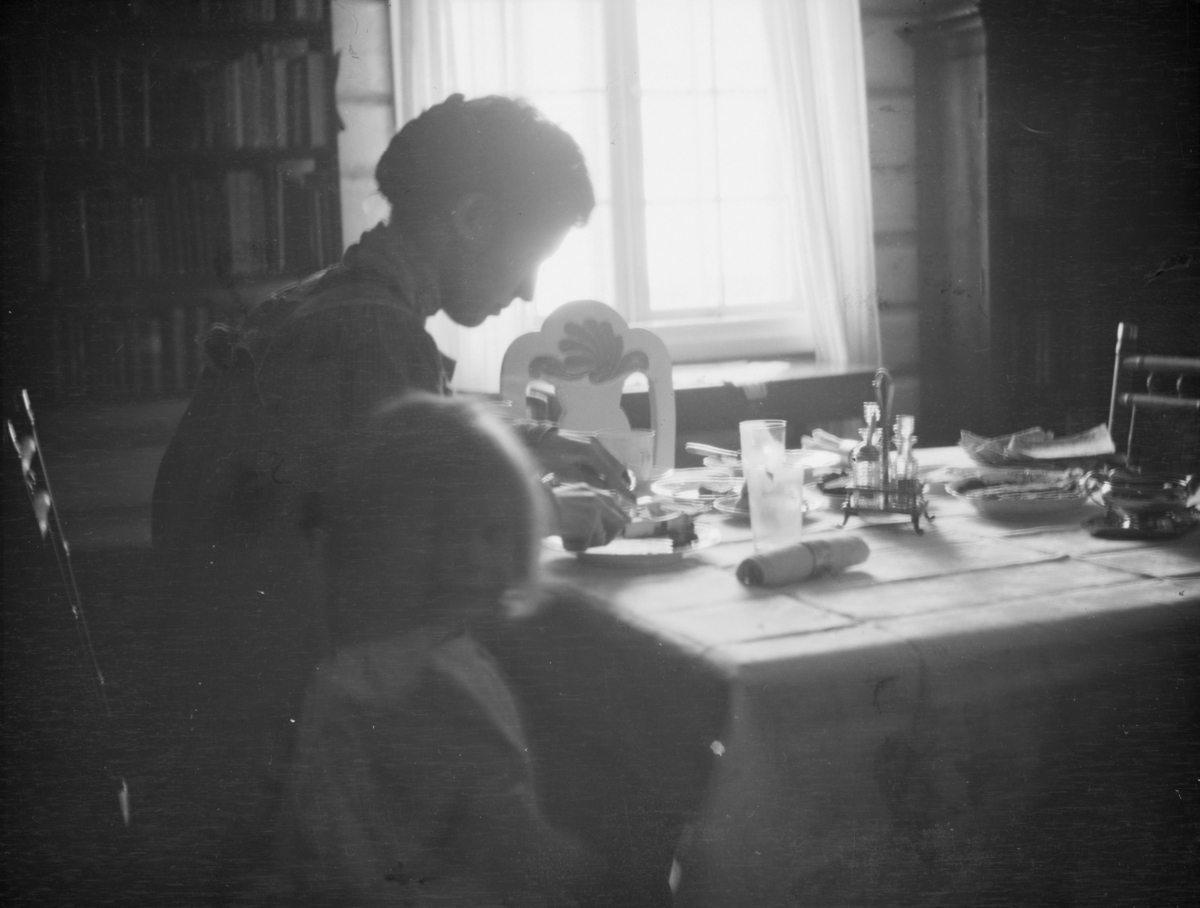 Kvinne med barn ved et kjøkkenbord