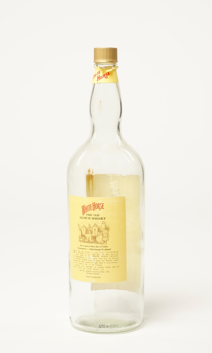 En flaske på 4,5 l whisky. White Horse fine old scotch whisky. Original papp-emballasje er intakt. Skrukork,
som er gullfarget.