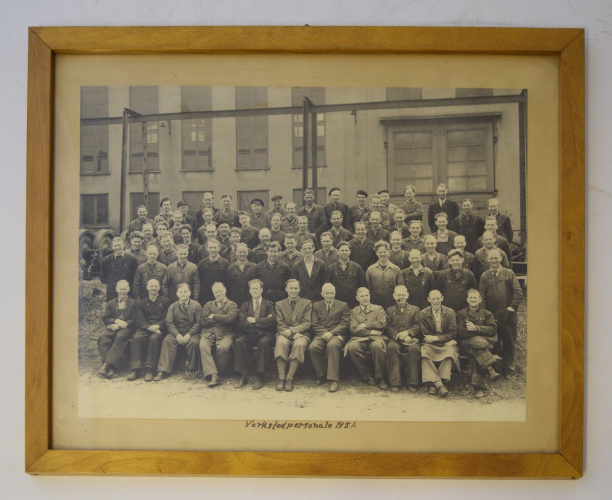 Verkstedpersonale 1951 oppstilt utenfor bygning. Første rekke er sittende, og herrene i midten av rekken er vellkledde.