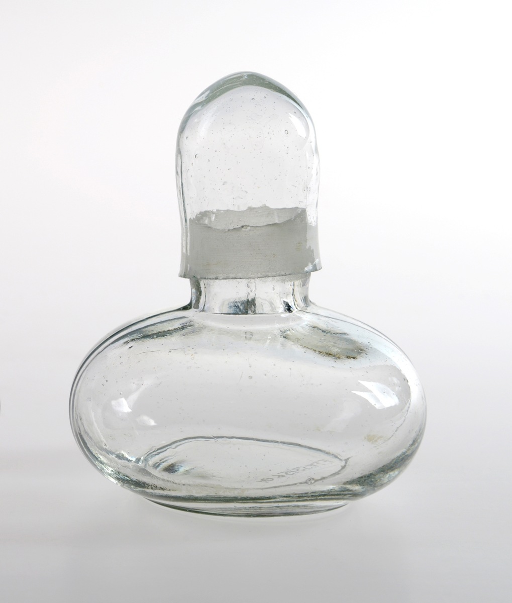 Rund liten parfymeflakong av glass med topp.