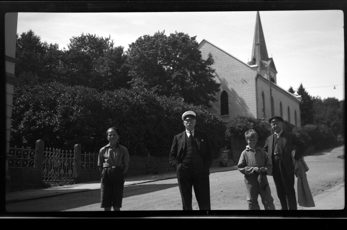 Bjørn Reymert og hans far Christen Reymert står sammen med Rolf Sundt jr. og hans far Rolf Sundt sr.  foran Frelserens kirke i Farsund.