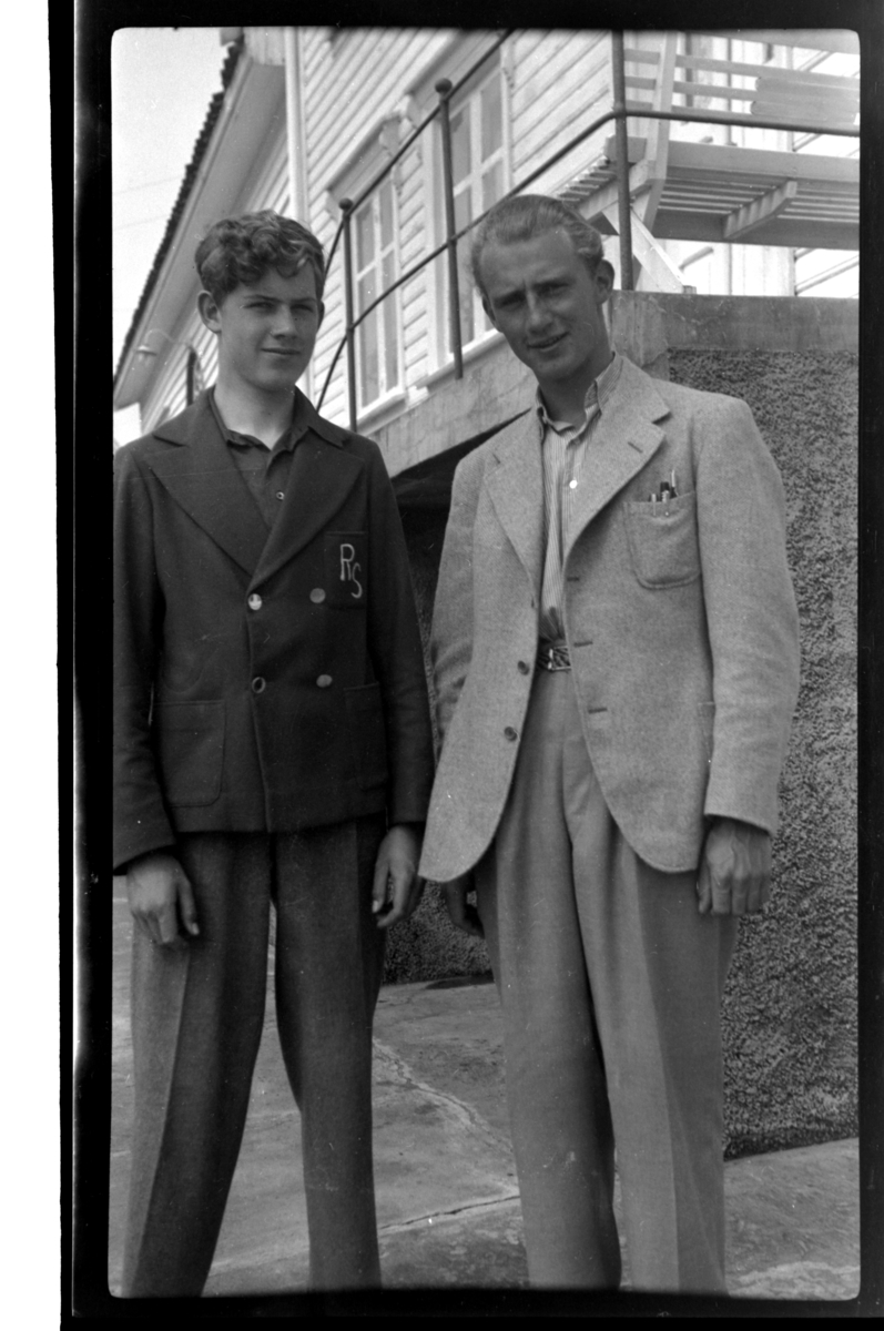 Brødrene Rolf jr. og Julius Sundt står utenfor huset til Ludvig Fredriksen, Loshavn. Fotografert 1938.