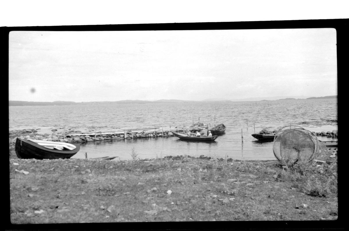 Liten småbåthavn. Robåt med tre gutter på vei inn. Fotografert ca. 1928.