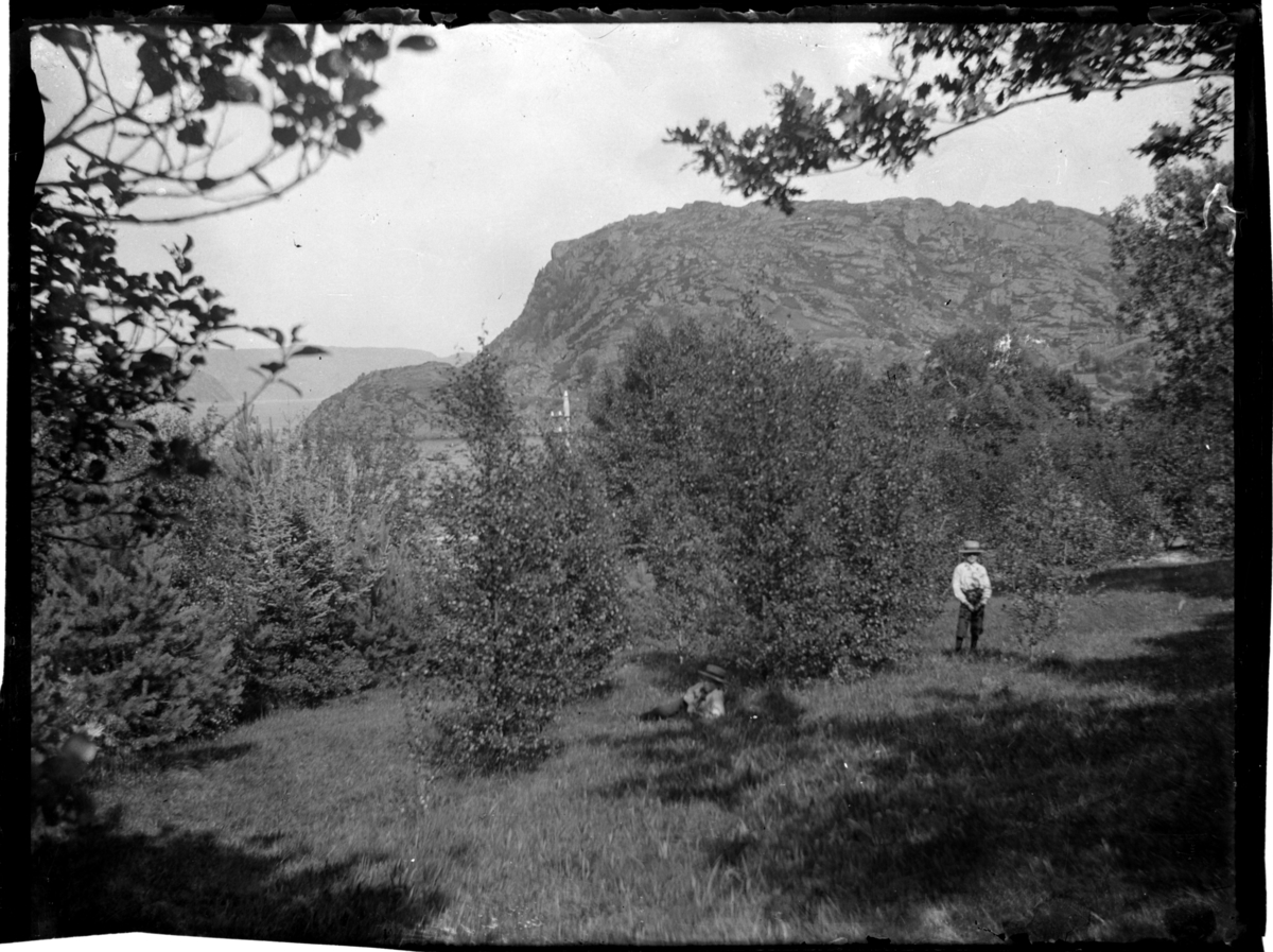 Fra Farøy med utsikt mot Spindsodden. To gutter med stråhatter i forgrunnen. Fotografert rundt 1904.