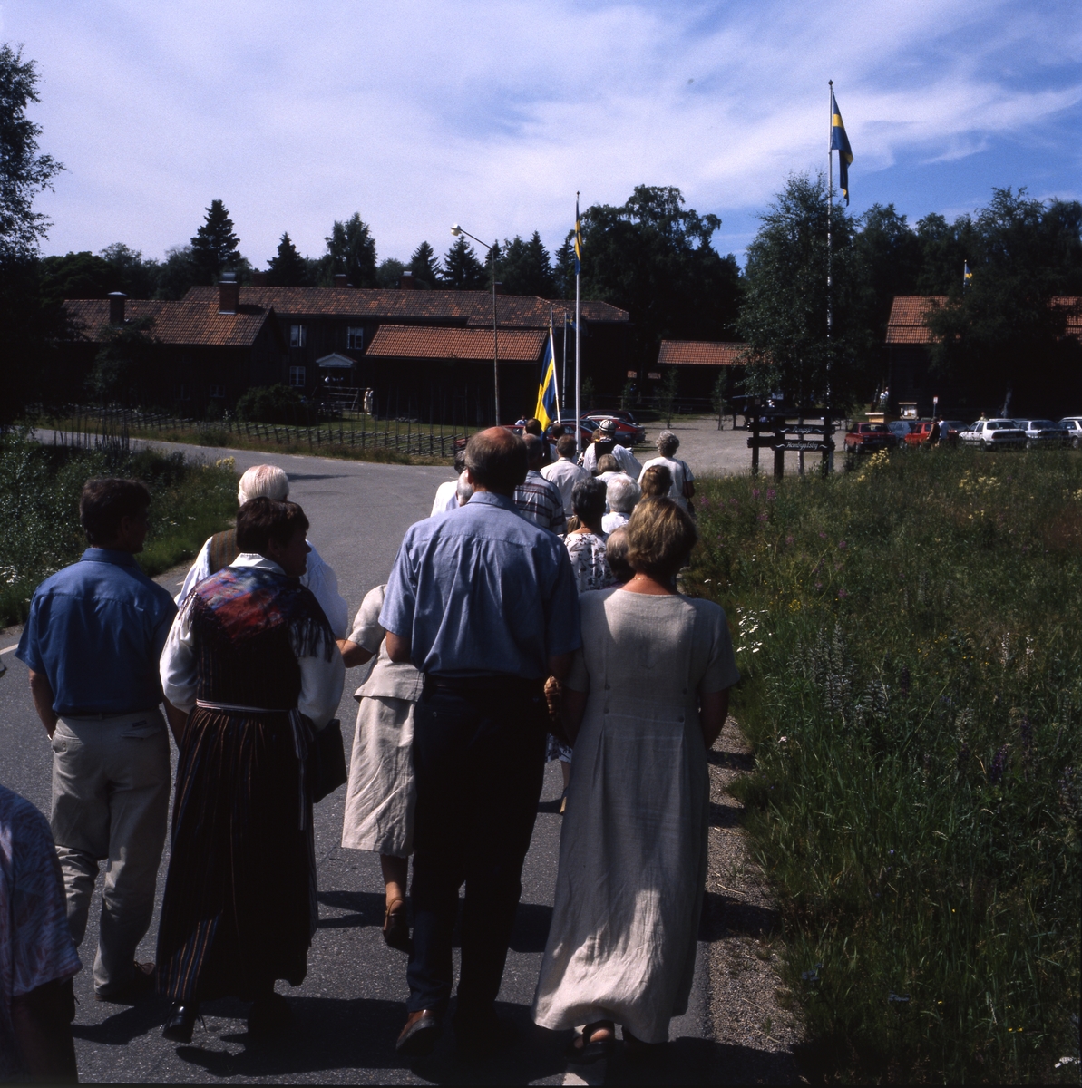 Rengsjöfesten 11 juli 1999. En grupp människor går efter fanbäraren mot Västerby hembygdsby.