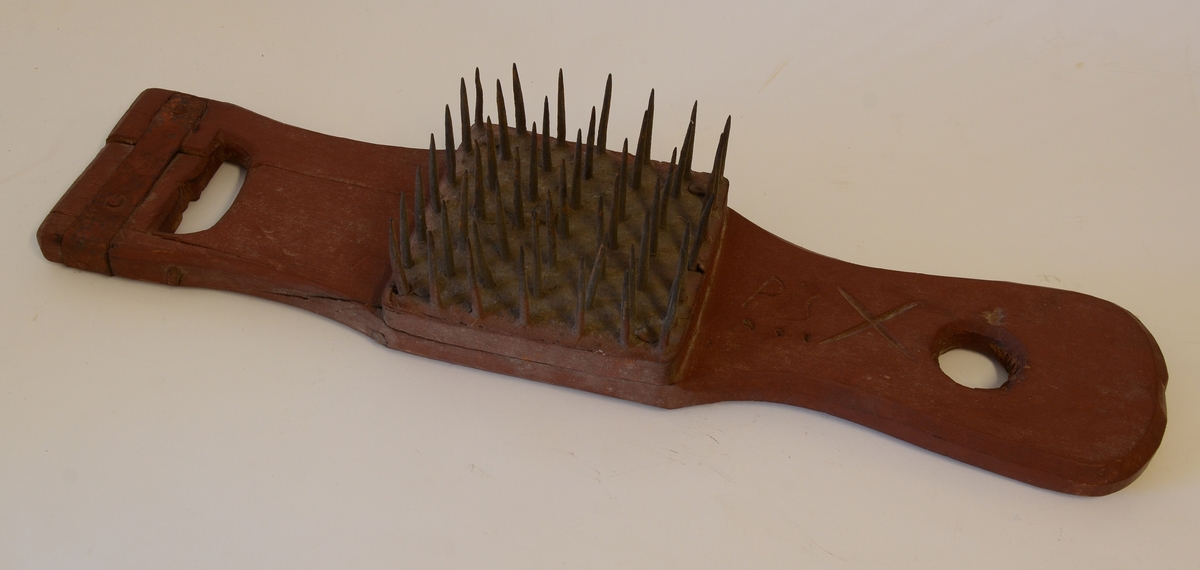 Lin- eller hamphäckla av trä med fyrkantig kam bestående av en fyrkantig träplatta, omdragen av ett järnband. I plattan är kamspikarna fästade. Ett handtag är lagat med ett järnband.