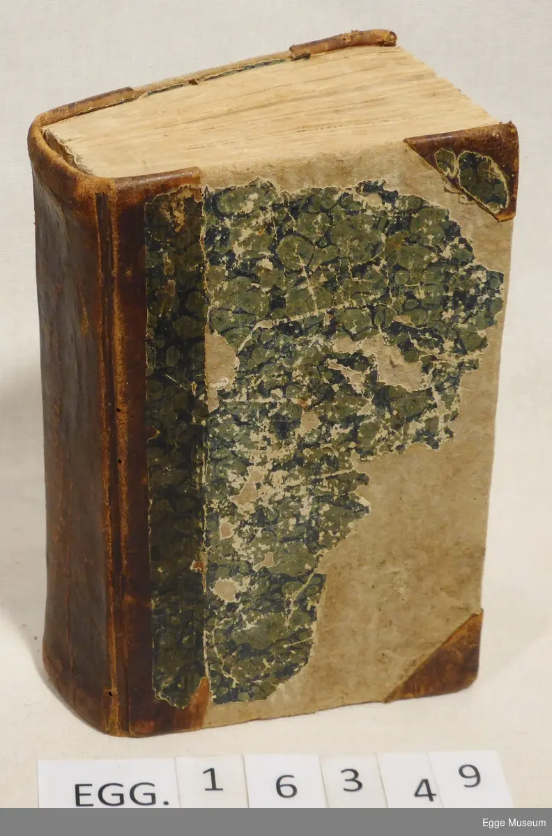 Rektangulær salmebok med stive permer, innbundet med brunt skinn i rygg og hjørner og grønt og blått marmorert papir limt på papp.