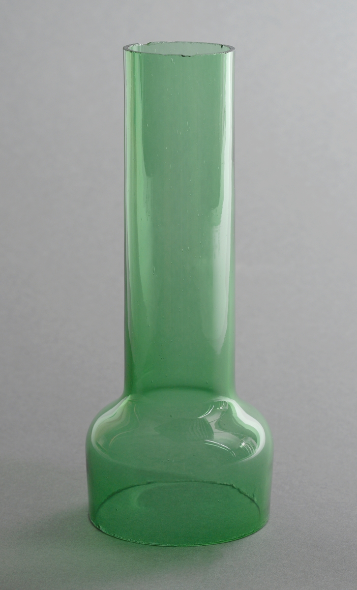 Todelt svibelglass i grønt håndblåst glass hvor svibeldel går oppi vasedel. Vasedelen er konisk formet, og svibeldelen av glasset er sylinderformet. Svibeldelen er i tillegg bredest øverst, som gir plass til svibelløken.