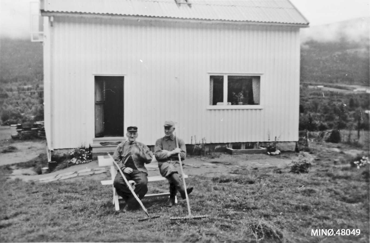 Håkon Søgarn og Alf Moen tar en pust i slåttearbeidet. 