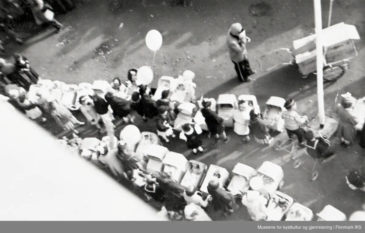 Nordkappfestivalen 1956. Under åpningen av Nordkappveien ble det arrangert dukkevogntog i Storgata. Utenfor posthuset fikk deltagerne servert ispinner.