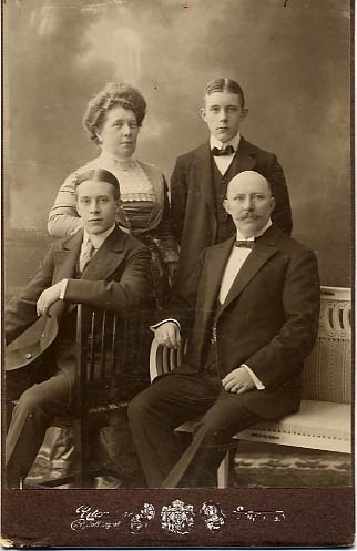 Kabinettsfotografi: familjen Gustafsson. En son och mannen sittande, hustrun och en annan son stående bakom.