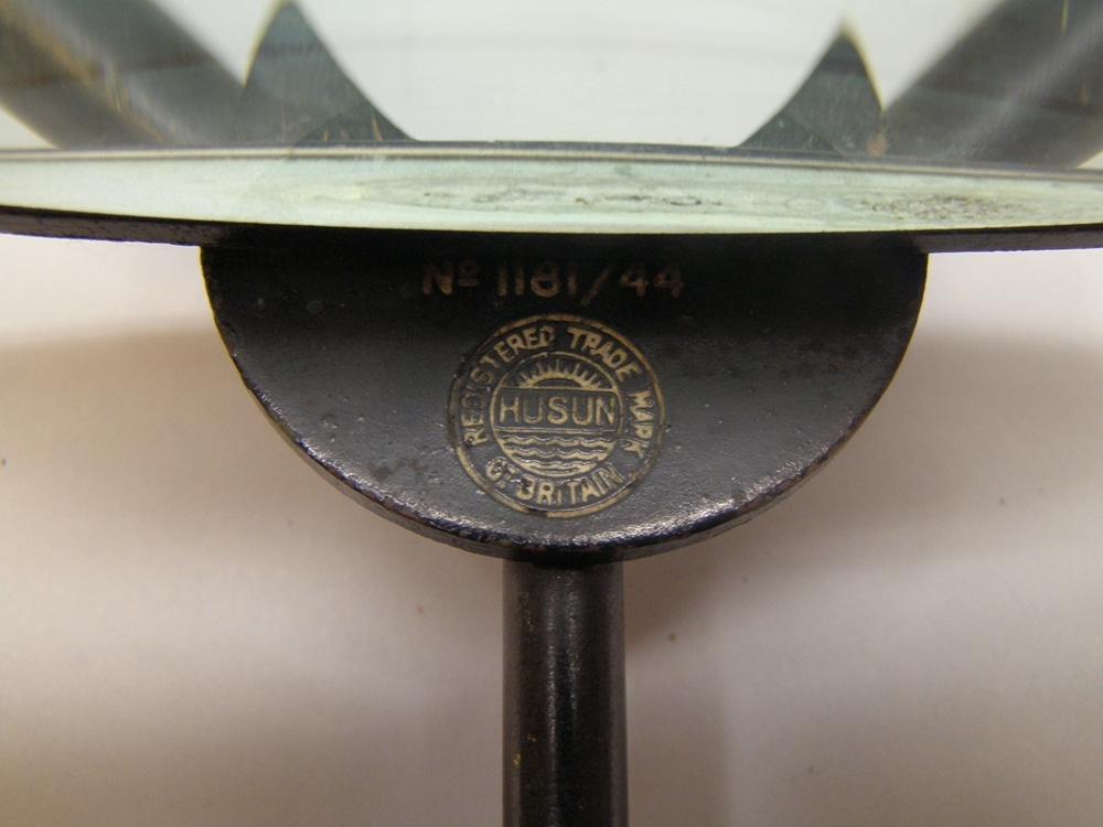 Instrument av mässing målad i svart kulör som tillhört ångfärjan Starke. Mitt på instrumentet är ett förstoringsglas fastsatt med ett gångjärn av mässing.