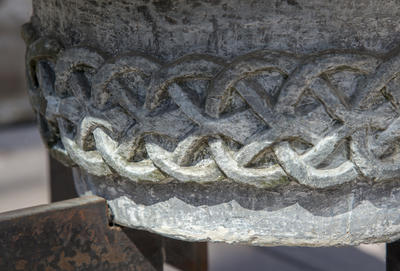 Nærbilde av mønsterbord med ringfletting på en døpefont i kleberstein.