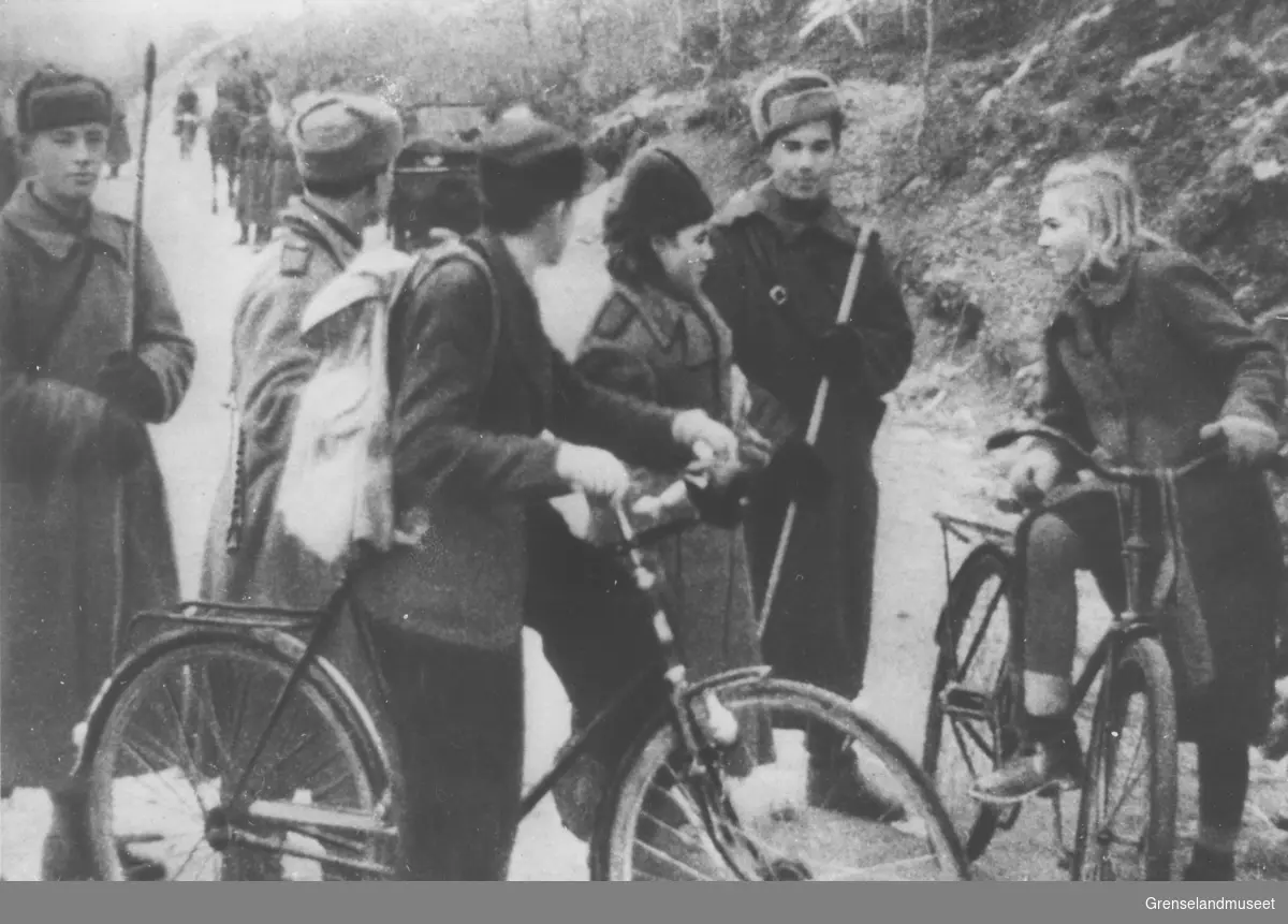 Samtaler mellom sovjetiske soldater og den norske sivilbefolkningen under frigjøringen av Sør-Varanger oktober 1944. Jenta på sykkelen er Edith Pedersen (f. Jensen) og gutten er Osvald Edvardsen.