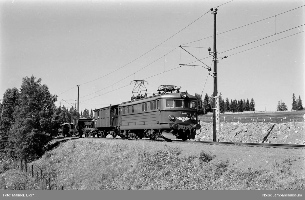 Arbeidstog med vogner lastet med pukk i nærheten av Eina stasjon. Toget trekkes av elektrisk lokomotiv type El 11 nr. 2094.