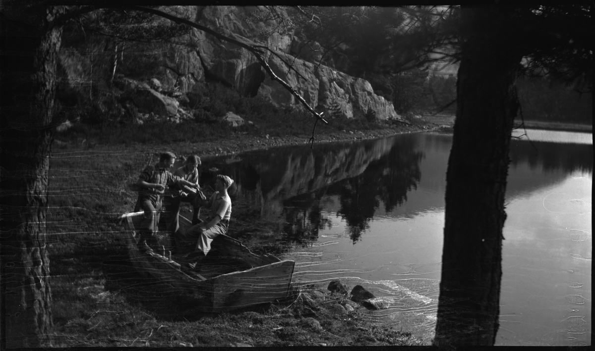 Wilhelm Hatleskog, Elmer Rodvelt og Ordin Andersen ror i en pram, har spisepause og leker ved et vann. Det er også bilde av et falleferdig uthus.