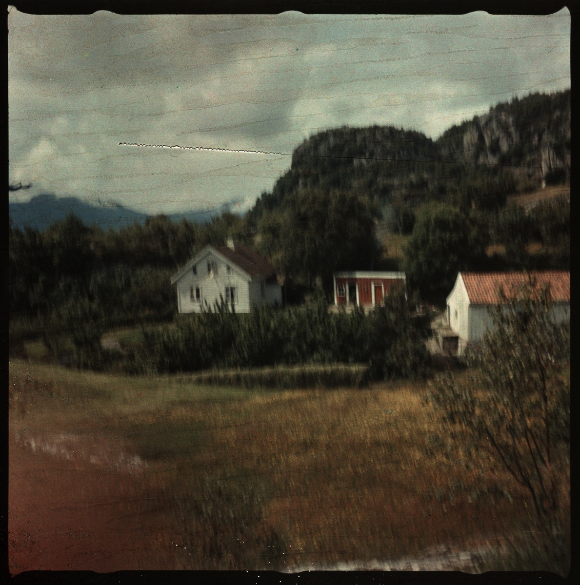 En gård på Bokn eller Ryfylke og et bilde av Lindtner som går langs en strand. Det ene bildet er et tidlig fargepositiv (transparent).