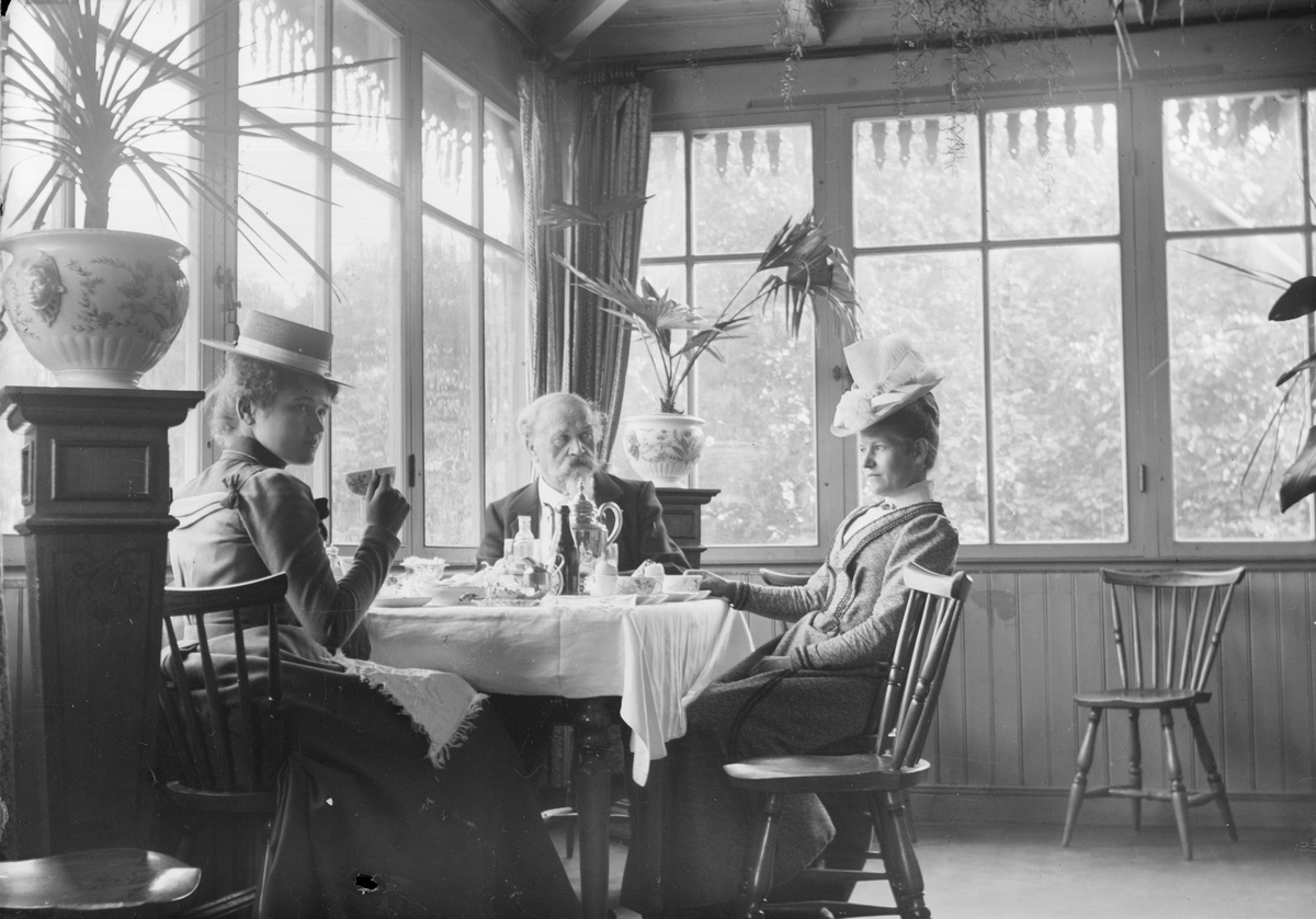 Sällskap vid frukostbord, sannolikt Ostis ateljé, Uppsala före 1914