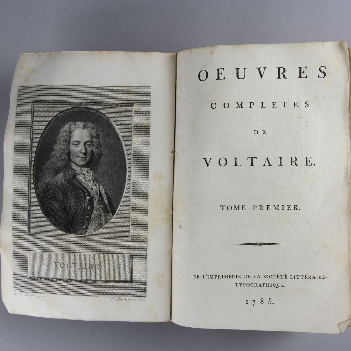 Bok, häftad,"Oeuvres complètes de Voltaire." del 6, tryckt 1785.
Pärm av gråblått papper, skurna snitt. Blekt rygg med pappersetikett med tryckt text med volymens namn och nummer.