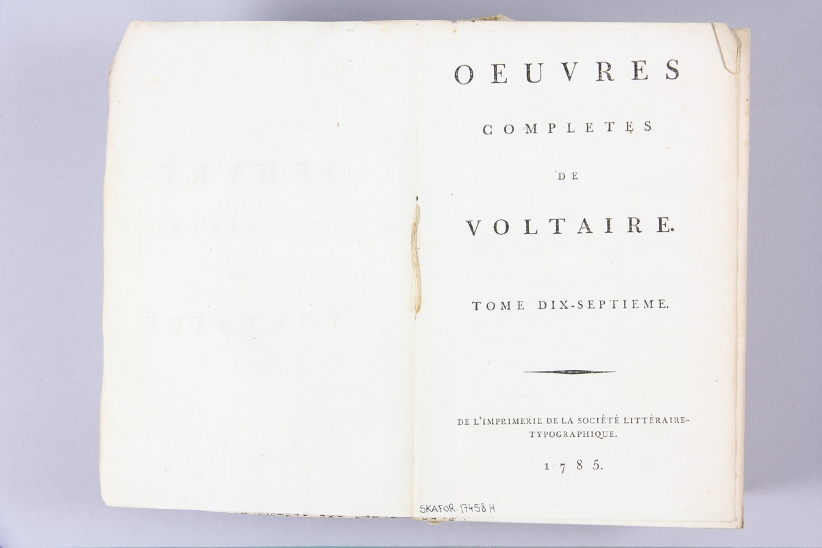 Bok, häftad,"Oeuvres complètes de Voltaire", del 17, tryckt 1785.
Pärm av gråblått papper, på pärmens baksida klistrad sida ur annan bok. Med skurna snitt. På ryggen klistrad pappersetikett med tryckt text samt volymens nummer. Ryggen blekt.