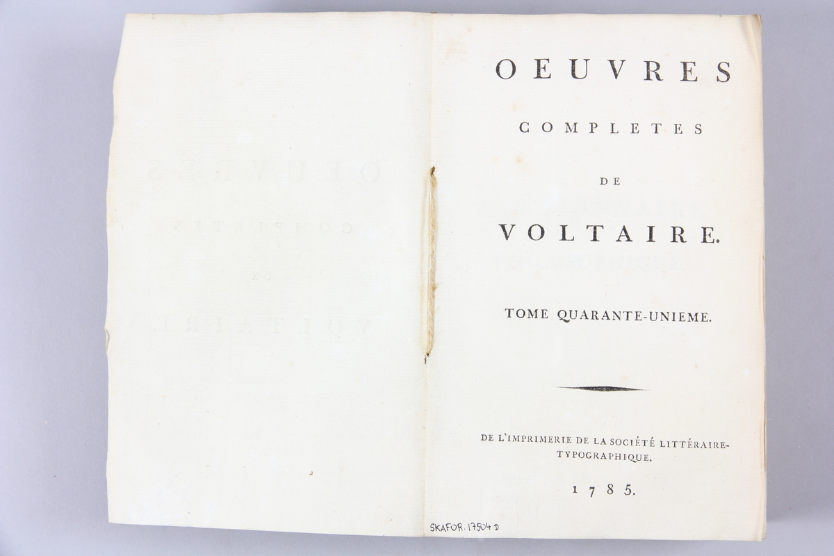 Bok, pappband,"Oeuvres complètes de Voltaire."  del 41, tryckt 1785.
Pärm av gråblått papper, på pärmens insidor klistrade sidor ur annan bok. Med skurna snitt. På ryggen pappersetikett med tryckt text med volymens namn och nummer. Ryggen blekt.