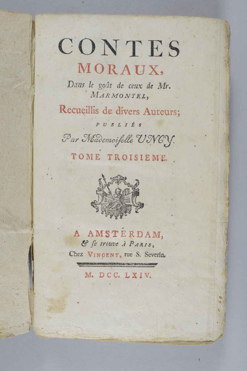 Bok, häftad,"Contes moraux", del 3, skriven av Marmontel, tryckt 1764 i Amsterdam.
Pärm av gråblått papper, oskuret snitt. Blekt rygg med pappersetikett med volymens namn och samlingsnummer.