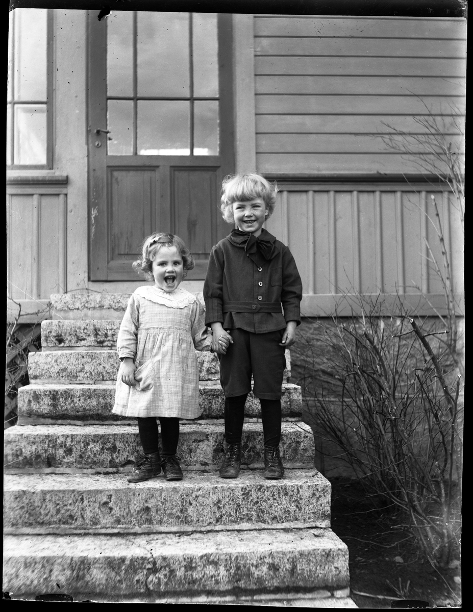 Ingenjör Adlers barn hand i hand på en stentrappa. I fotografens egna anteckningar står "Lillingen och Nalle Adler".