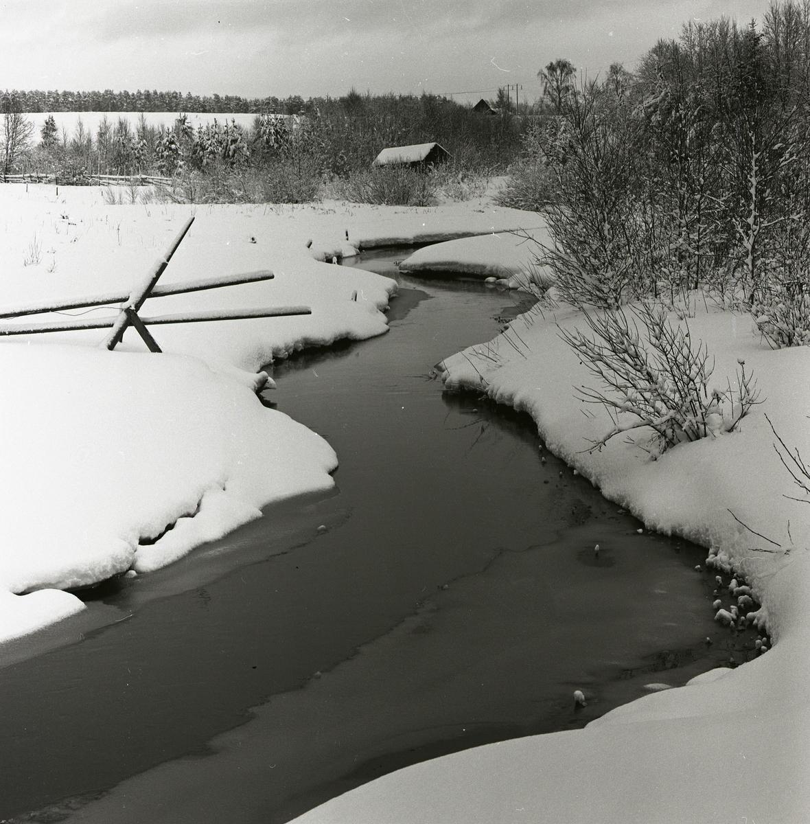 Ett vattendrag i snölandskap vid Hägnanbron, januari 1961.