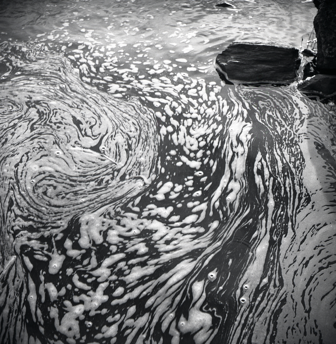 Vattenskum bildar ett mönster på vattnet i trakterna runt Knyssla den 1 maj 1959.