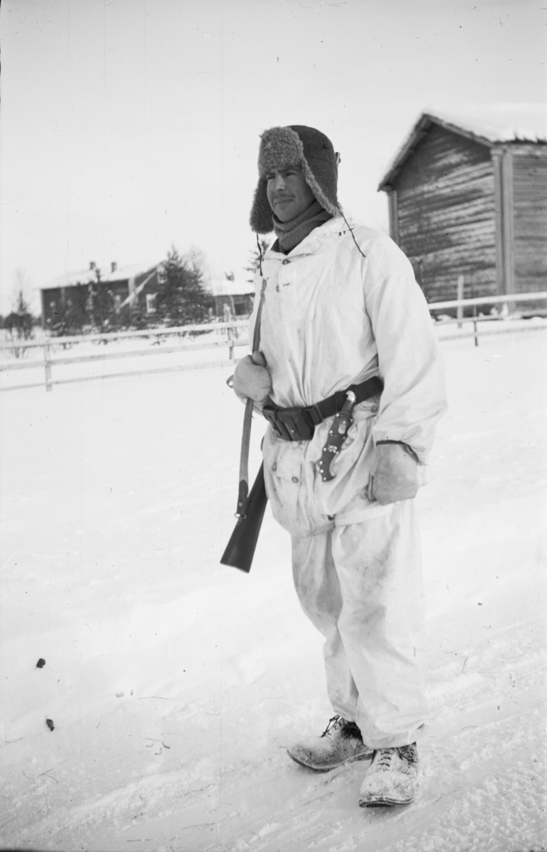 Porträttfoto av en vaktpost i vinteruniform vid Sveabasen i Posio, tillhörande Svenska frivilligkåren i Finland, F 19.
