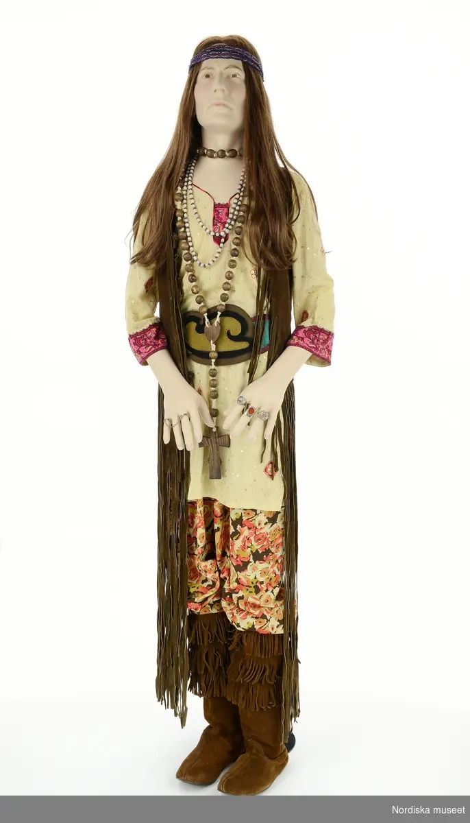 Hippie 1960, från utställningen Modemakt. Modellen är fotograferad för 360-visning. Information om kläderna se Relaterade objekt under Referenser. Tunika och hårband är rekvisita.