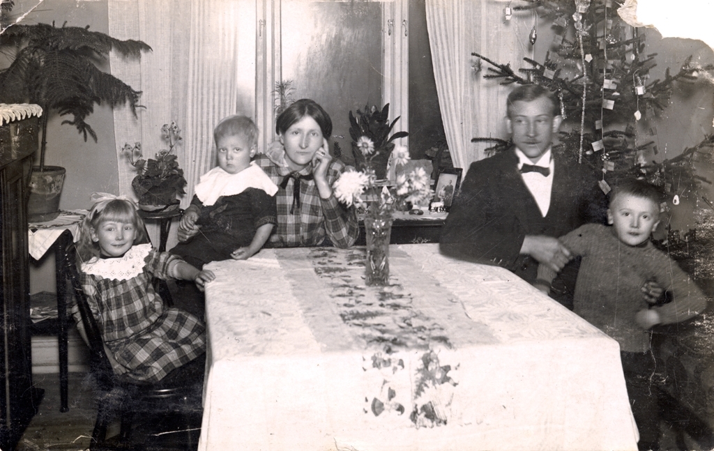 Familjen Träff sitter runt ett matbord i ett rum med julgran. Från vänster Agnes, Thore, Mariana, Oskar och Helge.