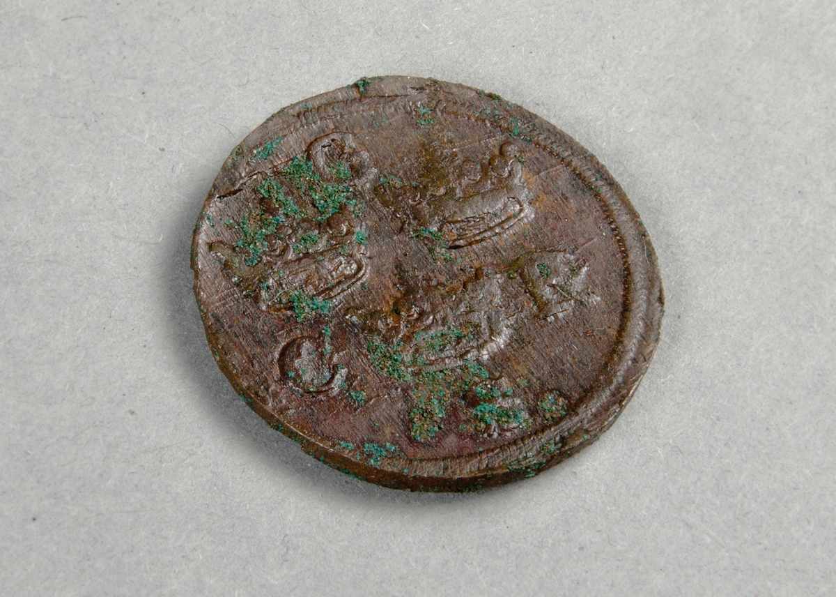 Mynt av kopparlegering. 1/4 öre silvermynt präglat 1656 under Karl X Gustavs regeringstid. Tre kronor på åtsidan och ett lejon under en krona på frånsidan.