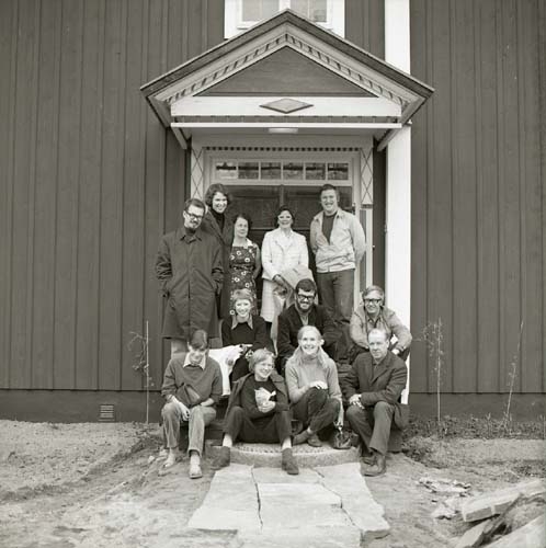 En grupp står uppställda för fotografering under ett förtak vid gården Sunnanåker, 1970.