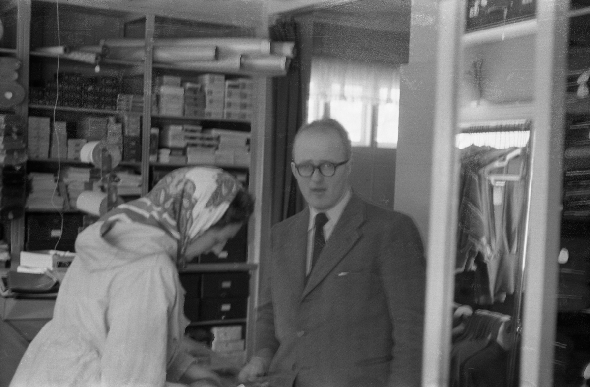 Reidar Aschim og ei ukjent kvinne (kunde?) avbildet trolig inne i Lena Manufakturforretning mars 1954.