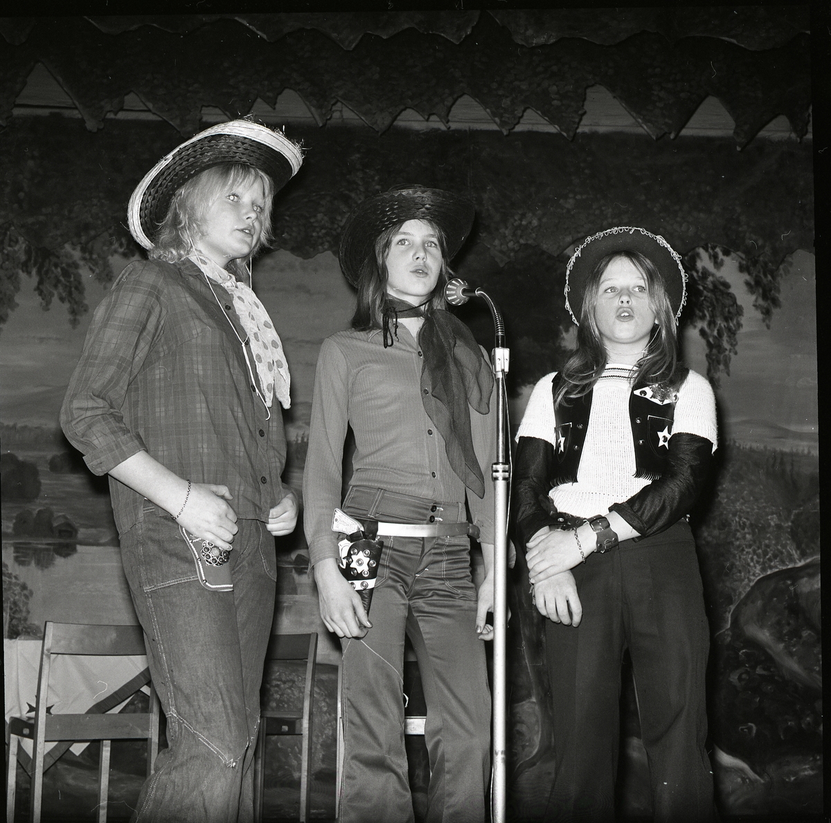 Tre flickor klädda i cowboykläder står på en scen och sjunger, 1972.