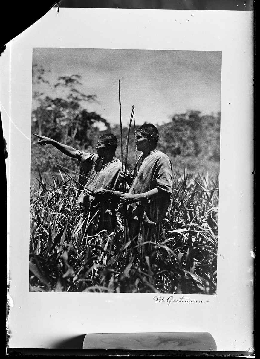 Två män med pilbågar står på ett fält. Bilden är signerad Rob. Gerstmann. I Harald Olssons anteckningar står det "27 rep. för Folke Olsson".