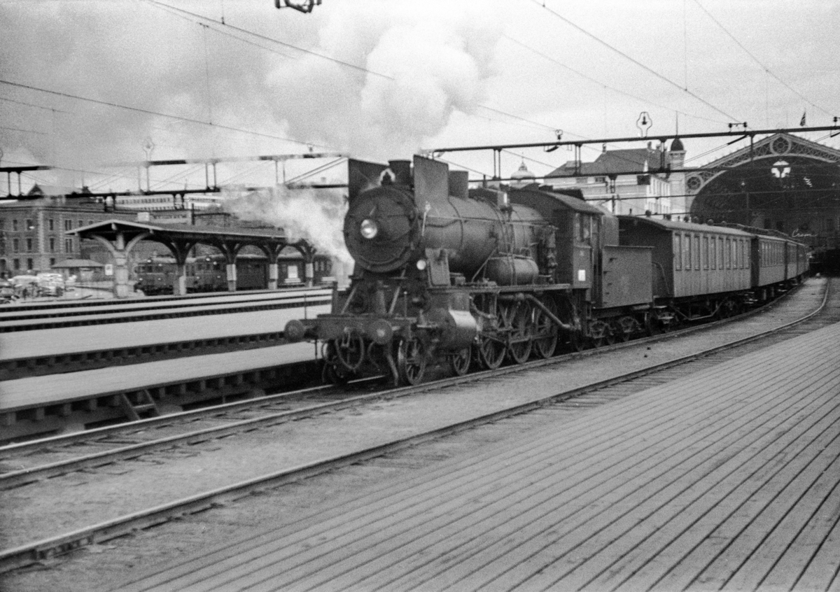 Persontog til Gjørvikbanen på Oslo Østbanestasjon. Toget trekkes av damplokomotiv type 30b nr. 348.