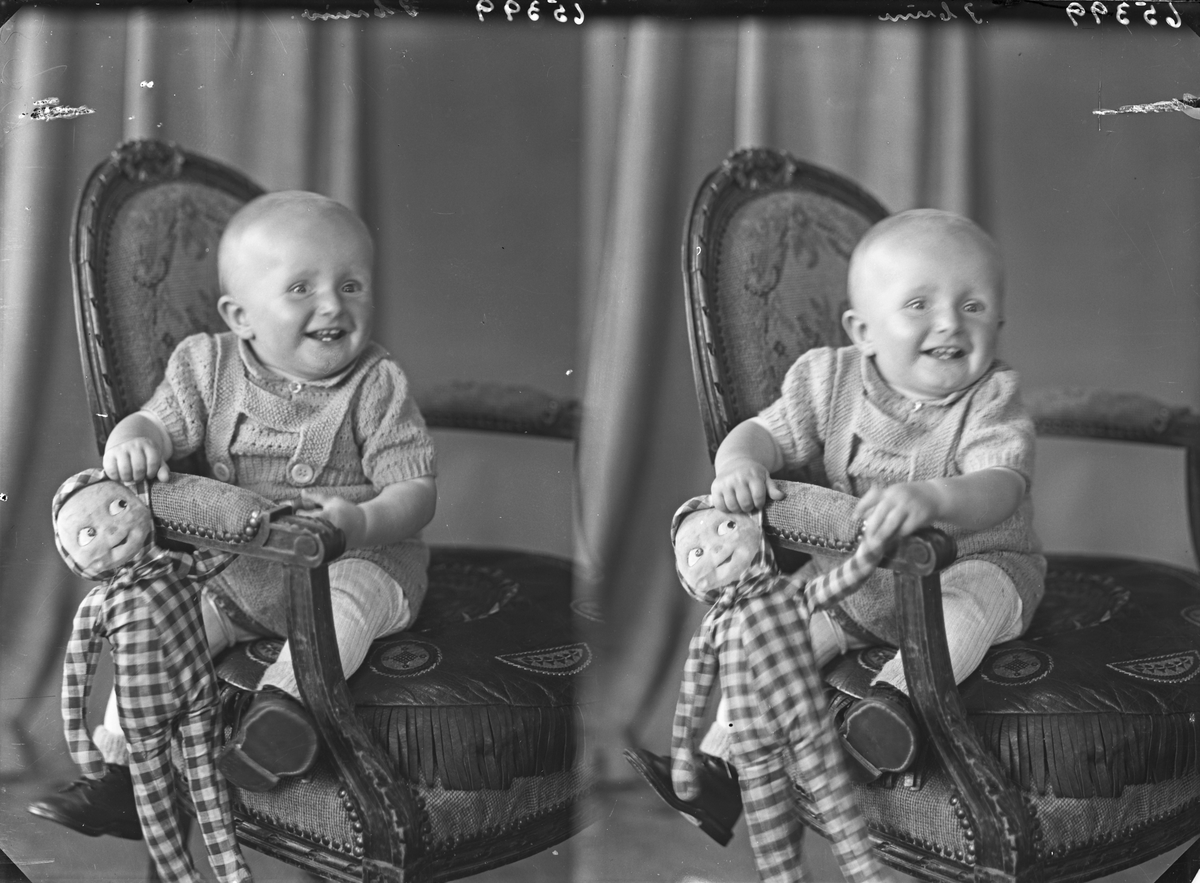 Portrett. Ung gutt i strikket drakt med en dukke. Bestilt av Ola Eide. Muslandsvåg.