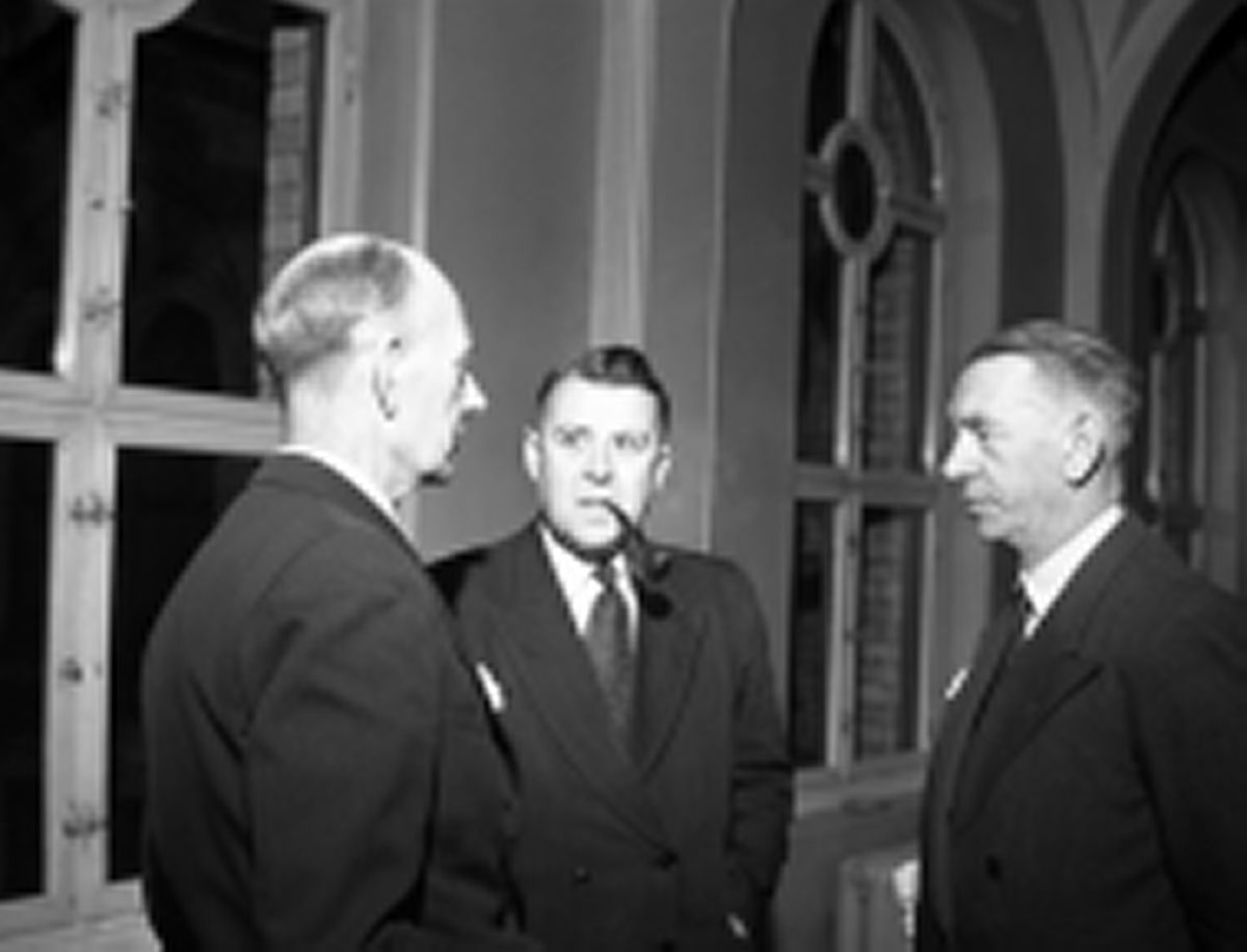 Einar Gerhardsen til venstre i samtale med Oscar Torp til høyre i Stortinget. Ukjent person i midten.