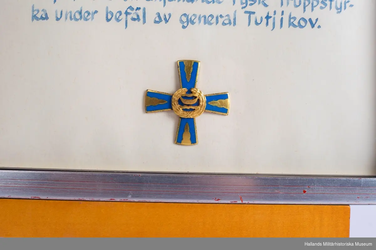 Siikajoki-korset. Inglasad med ram. Korset samt minnestext.