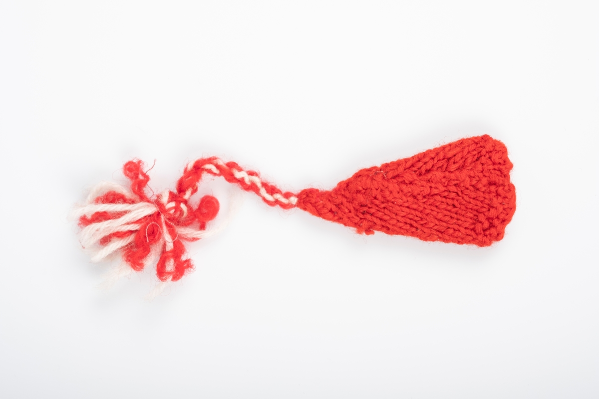 En liten rød strikket lue med en rød og hvit dusk. Det er brodert "Grini" på luen. Luen ligner en nisselue.