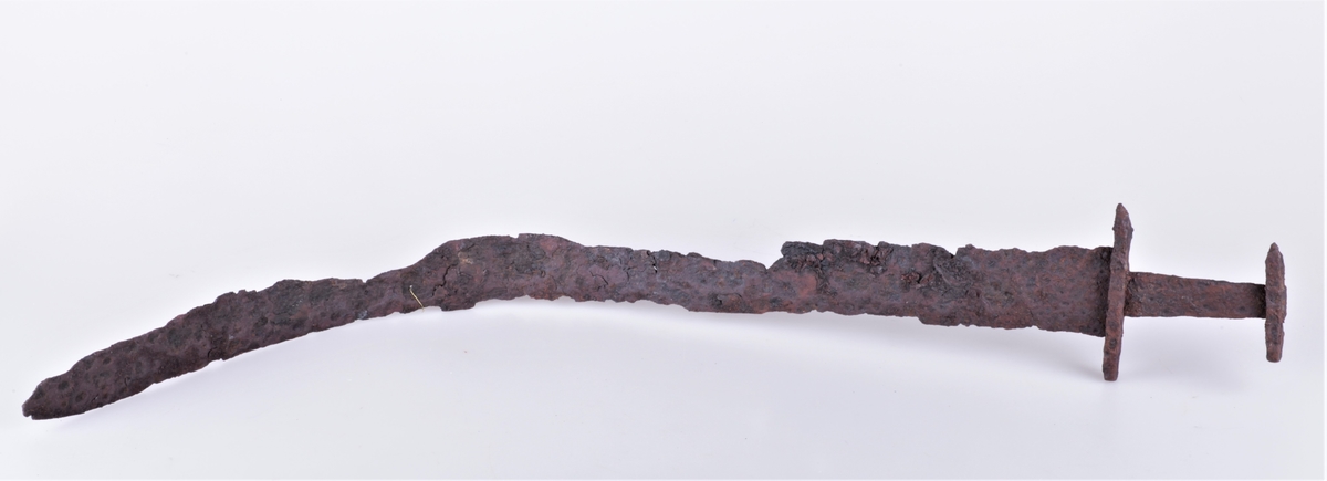 Tveegget sverd i jern av typen R. 489 fra vikingtiden. Funnet på Gile 1909. Klingen noe krøkt.