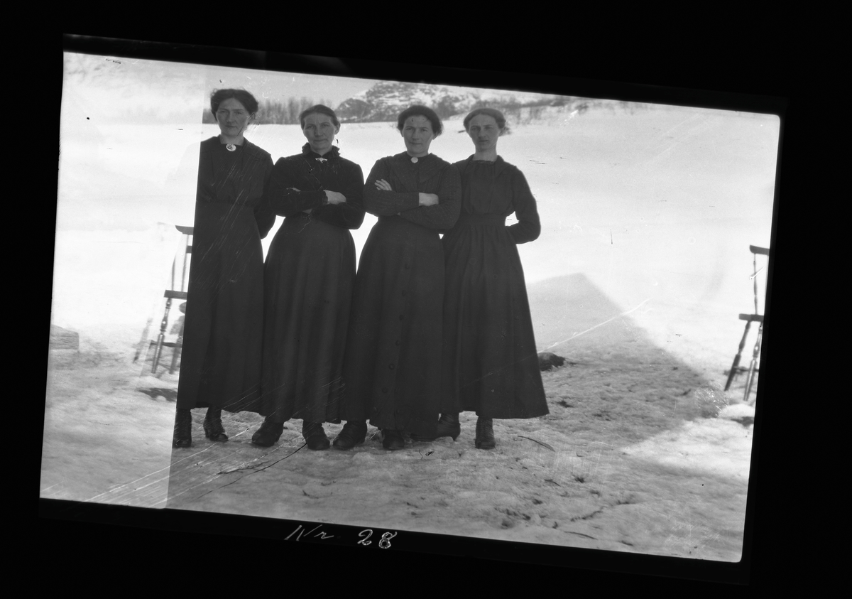Gruppebilde av fire kvinner stående på gårdstun.