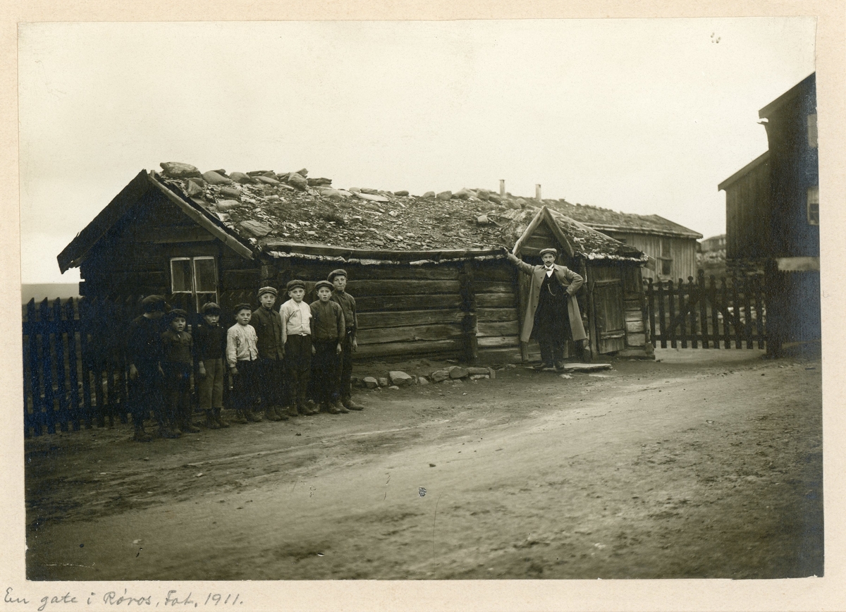 Unge gutter og en mann ved bebyggelse langs "Bikkjeflata" i Spell-Olaveien på Haugan på Røros i 1911.