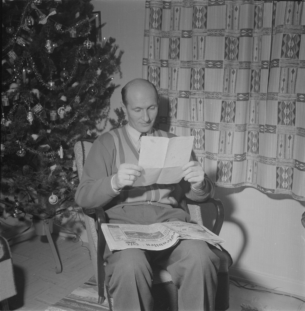 Mann leser brev. Juletre